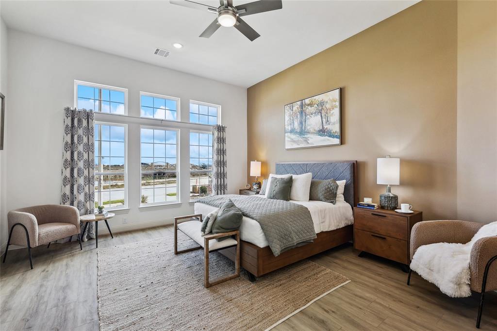 1604 Casting Ridge Mesquite, TX 75181 - Photo 17 of 38 Spacious bedroom featuring multiple large windows, wood-finish flooring, a ceiling fan with integrated lighting, and neutral wall tones