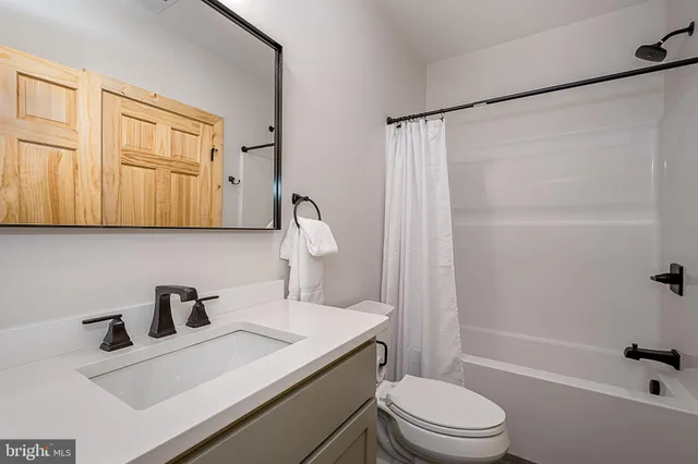 a bathroom with a sink a toilet and a large mirror