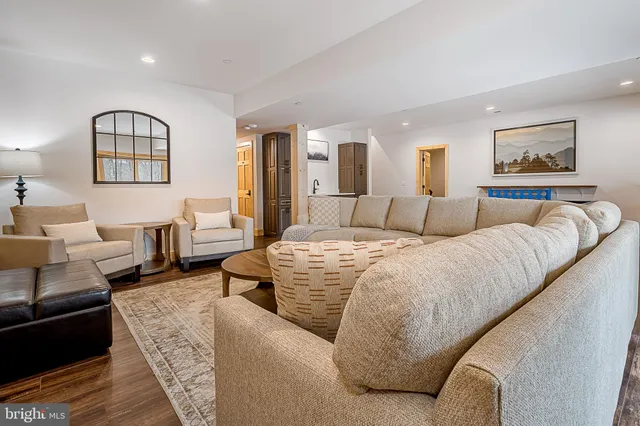 a room with wooden floor pool table and windows