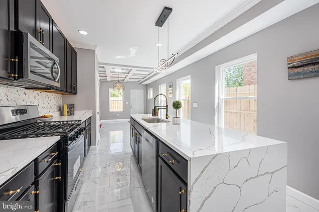 a kitchen with stainless steel appliances granite countertop a sink stove and refrigerator