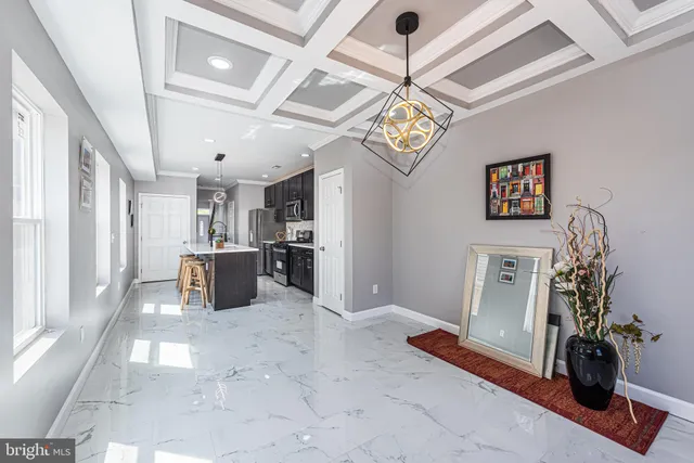 a view of a room with stainless steel appliances wooden floor and chandelier