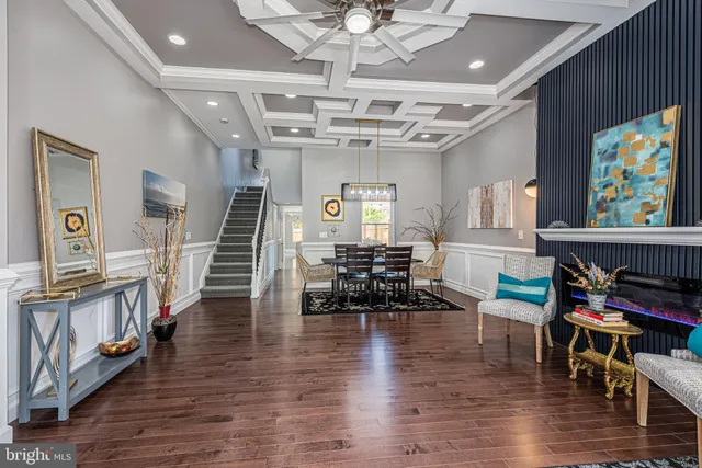 a livingroom with furniture a chandelier and wooden floor