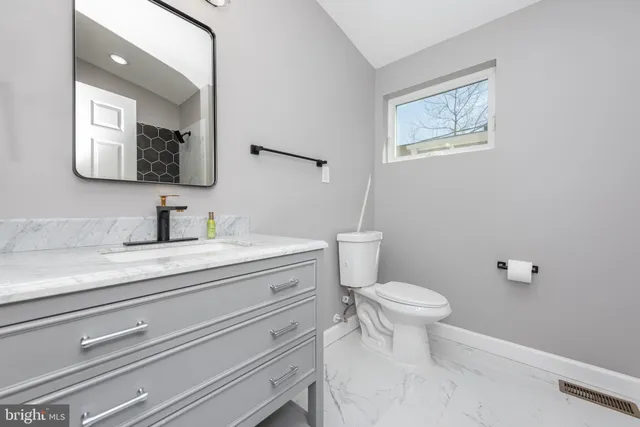 a bathroom with a toilet sink and mirror