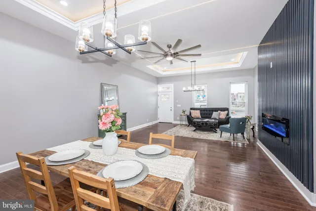 a view of a dining room with furniture a chandelier and wooden floor