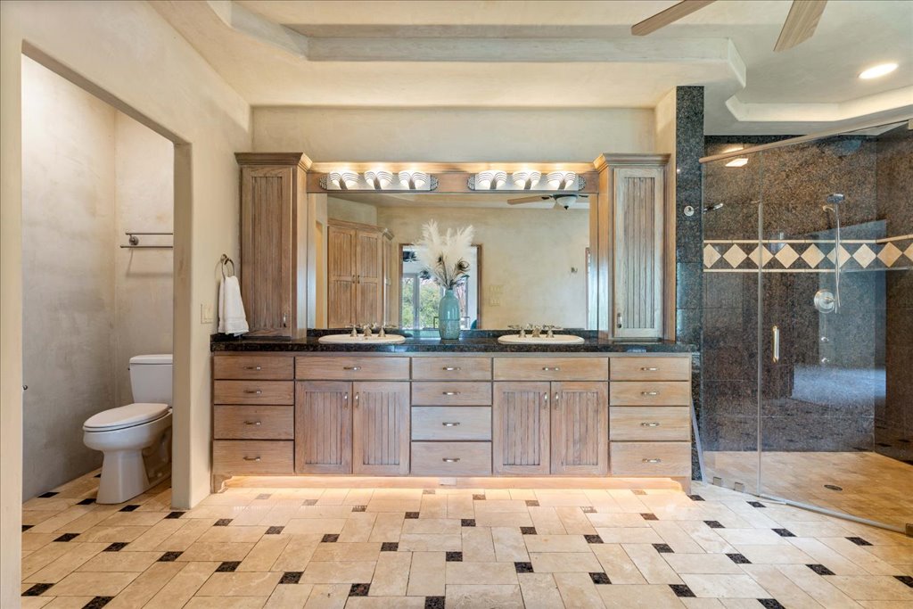 24736 Travis Lakeside Cove, Unit A Spicewood, TX 78669 - Photo 16 of 36 a bathroom with a sink a toilet and a large mirror