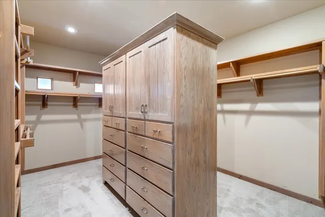 a view of an empty room with furniture and wooden shelves