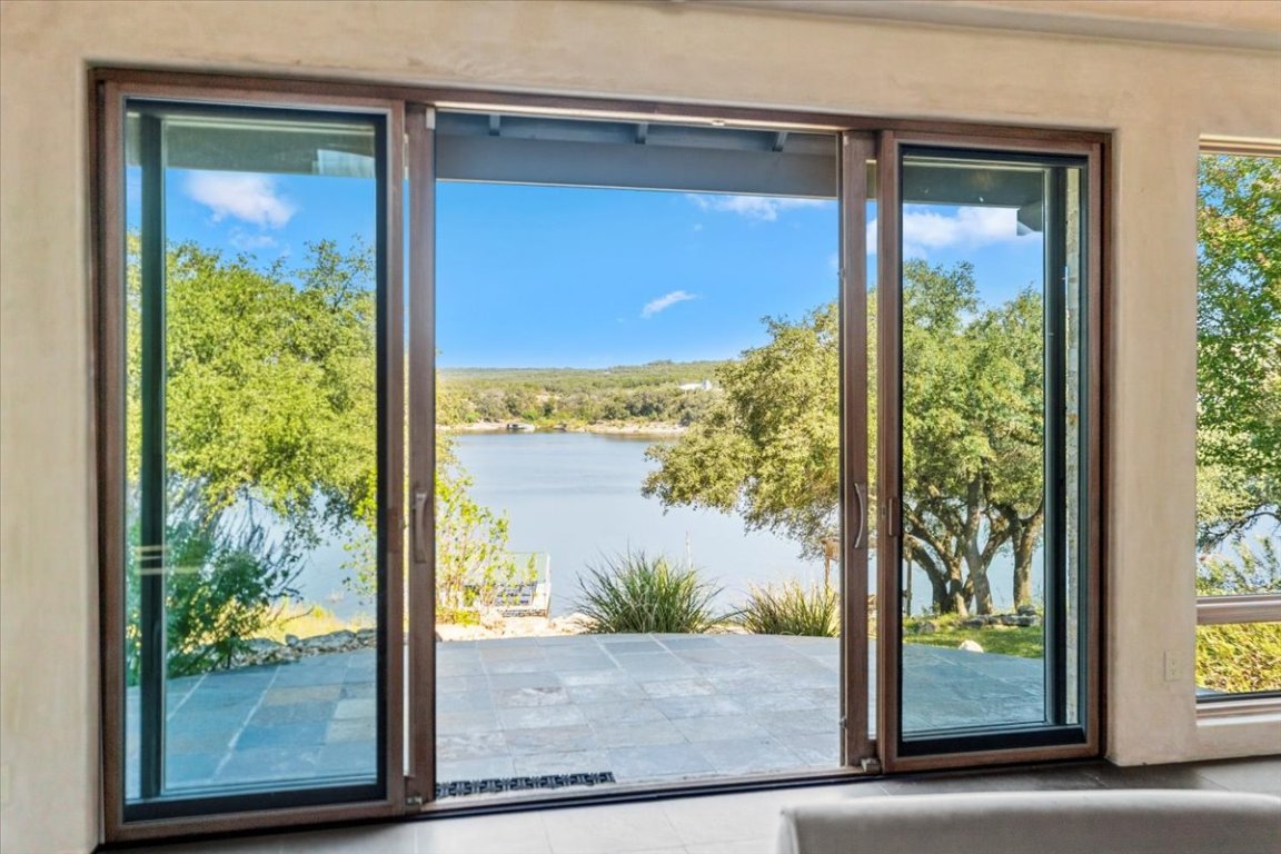 24736 Travis Lakeside Cove, Unit A Spicewood, TX 78669 - Photo 27 of 36 a view of a glass door with a from a window