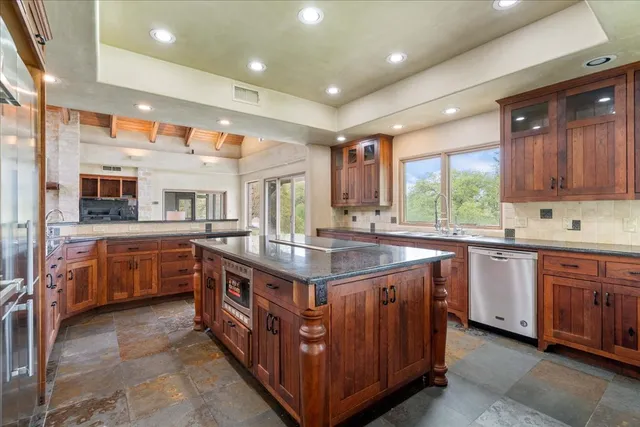 a kitchen with stainless steel appliances granite countertop a stove a sink and a refrigerator