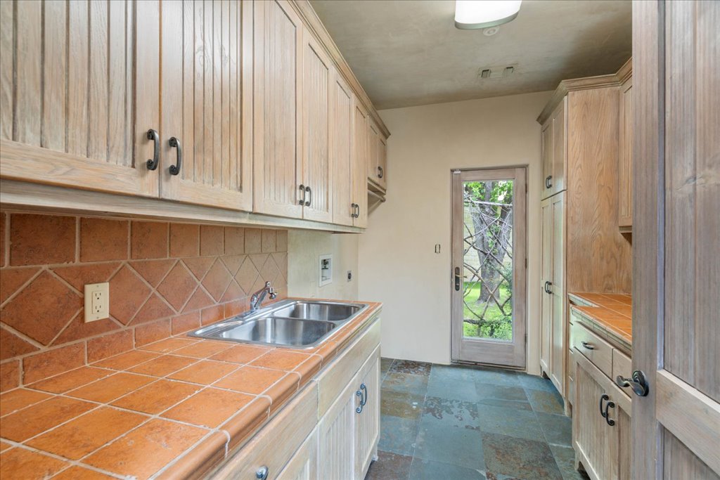 24736 Travis Lakeside Cove, Unit A Spicewood, TX 78669 - Photo 7 of 36 a kitchen with a sink and cabinets
