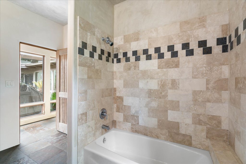 24736 Travis Lakeside Cove, Unit A Spicewood, TX 78669 - Photo 10 of 36 a bathroom with a bathtub and a shower