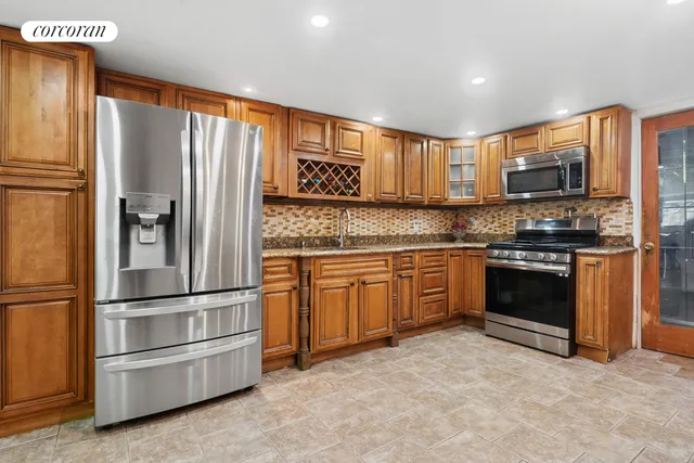 a kitchen with granite countertop a refrigerator stove and microwave