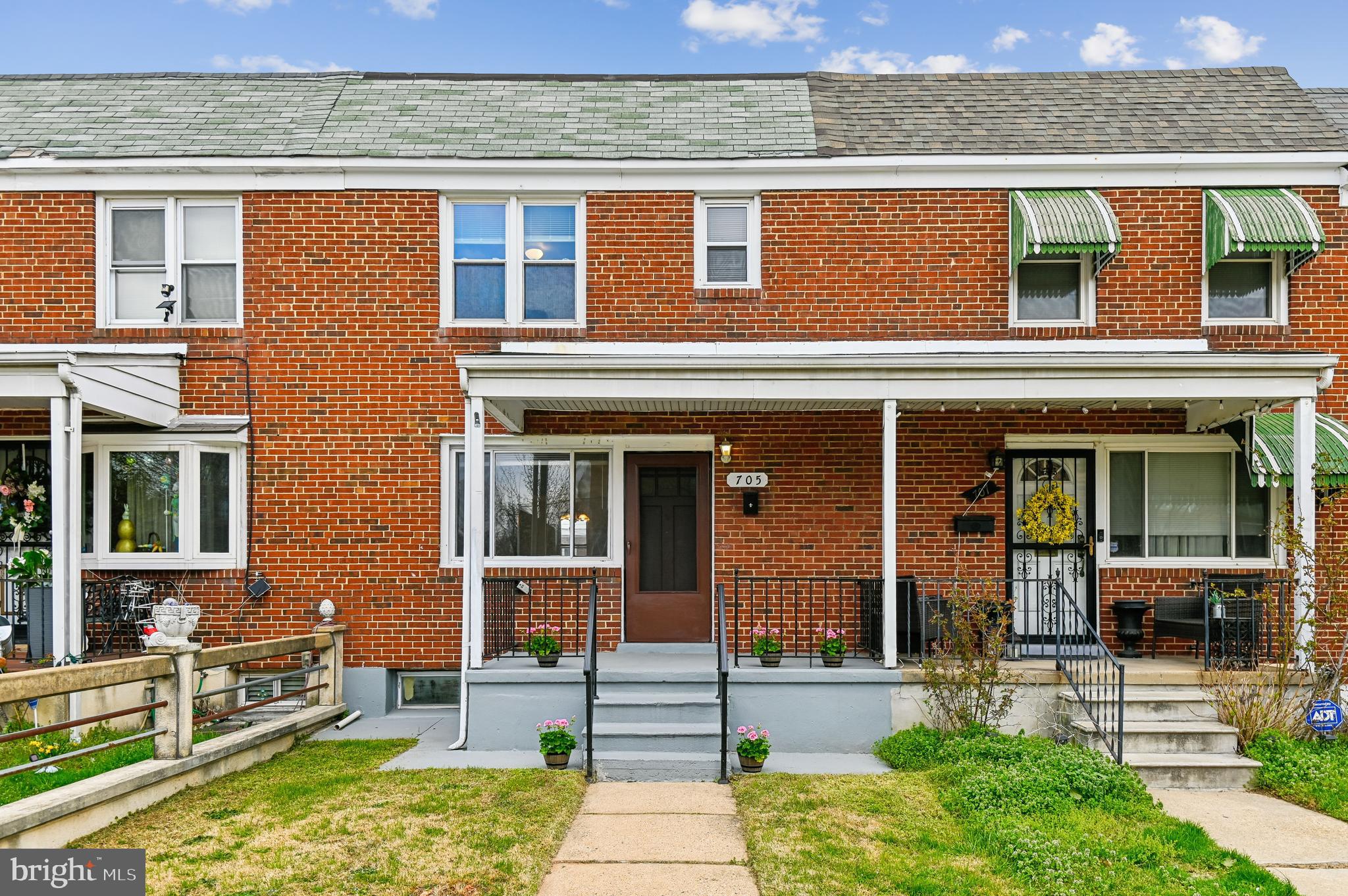front view of a brick house with a yard