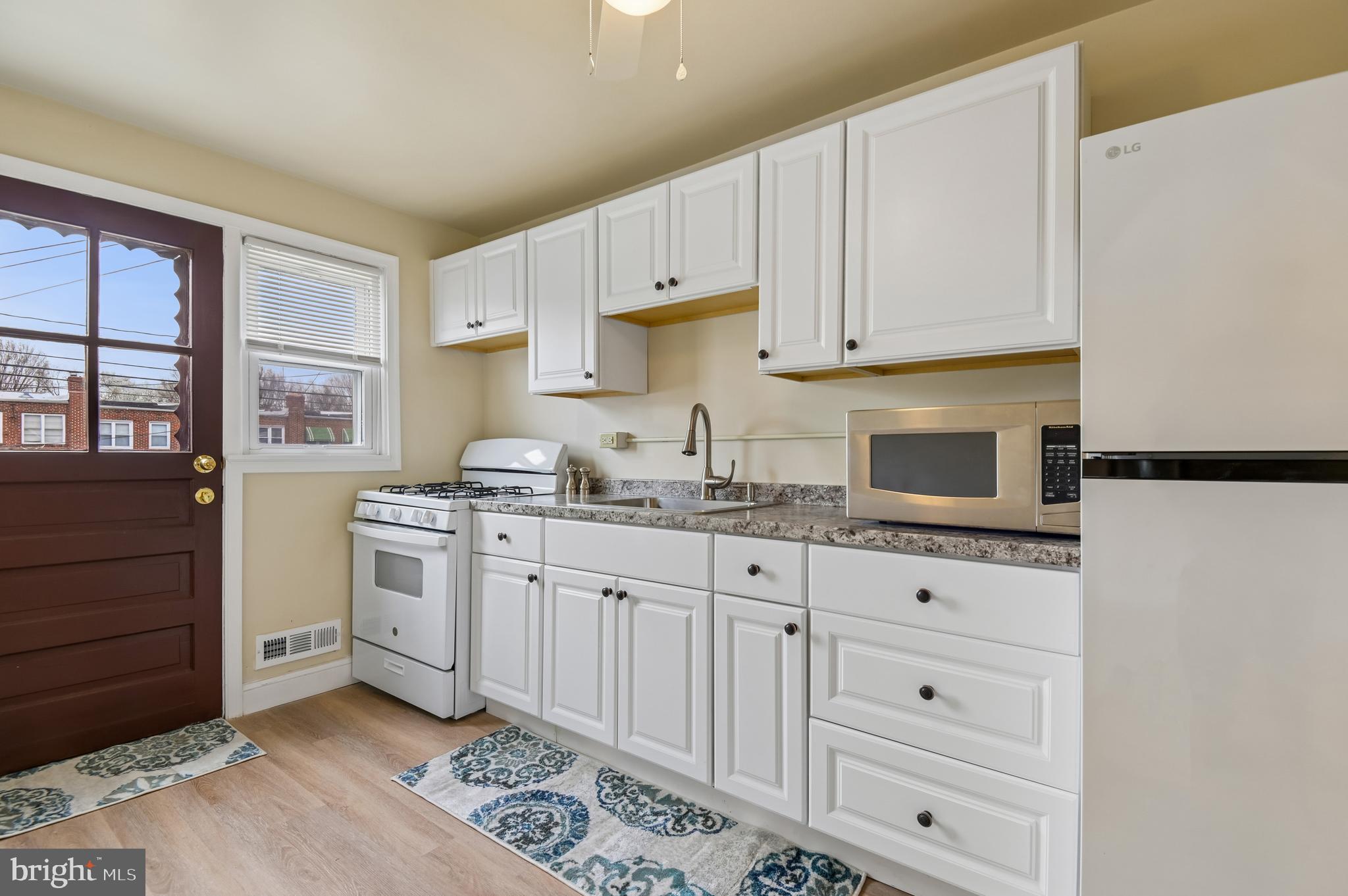 705 Tolna Street Baltimore, MD 21224 - Photo 5 of 34 a kitchen with granite countertop white cabinets and stainless steel appliances