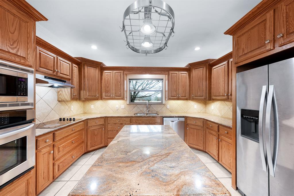 10471 Holly Creek Road Terrell, TX 75160 - Photo 11 of 40 a large kitchen with stainless steel appliances granite countertop a large counter top stove a sink dishwasher and microwave