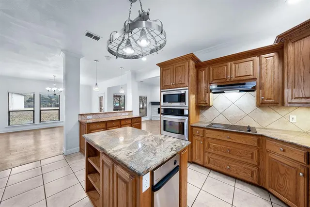 a kitchen with cabinets and chandelier