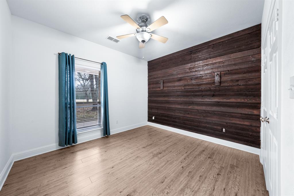 10471 Holly Creek Road Terrell, TX 75160 - Photo 25 of 40 a view of an empty room with wooden floor and a ceiling fan