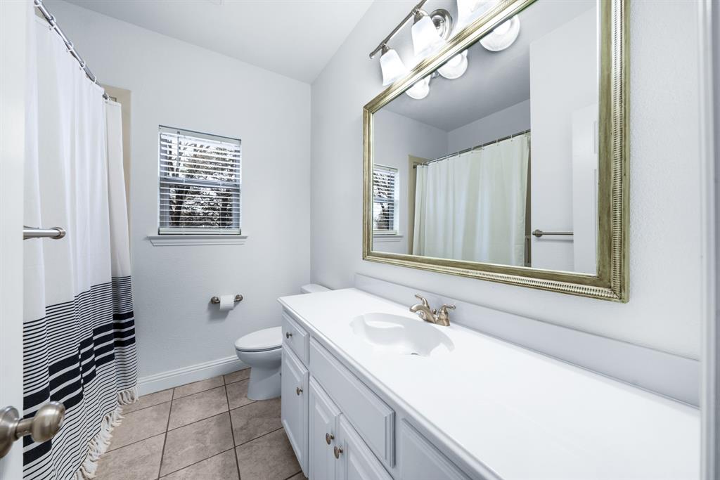 10471 Holly Creek Road Terrell, TX 75160 - Photo 26 of 40 a bathroom with a sink a toilet a mirror and shower