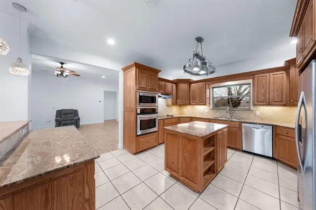 a kitchen with stainless steel appliances granite countertop a stove oven and a refrigerator