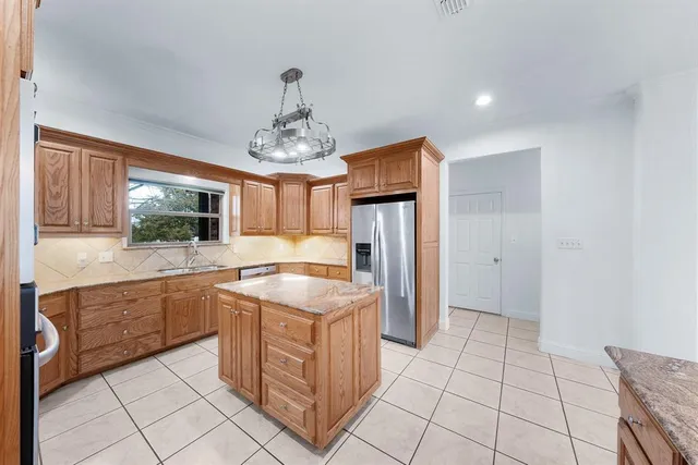 a kitchen with stainless steel appliances granite countertop a refrigerator and a sink
