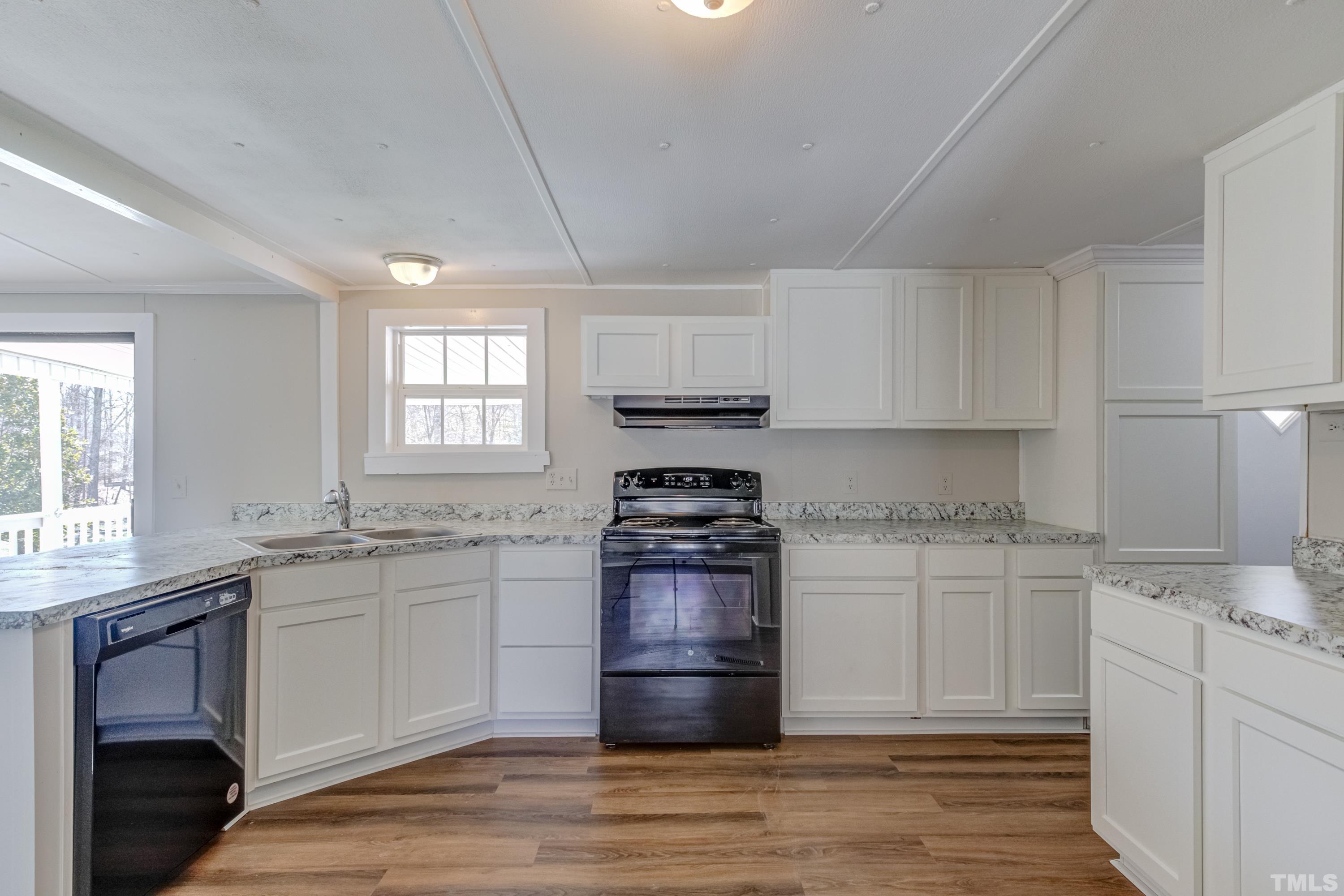 807 Lipscomb Road Angier, NC 27501 - Photo 23 of 39 a kitchen with stainless steel appliances granite countertop a stove a sink and white cabinets