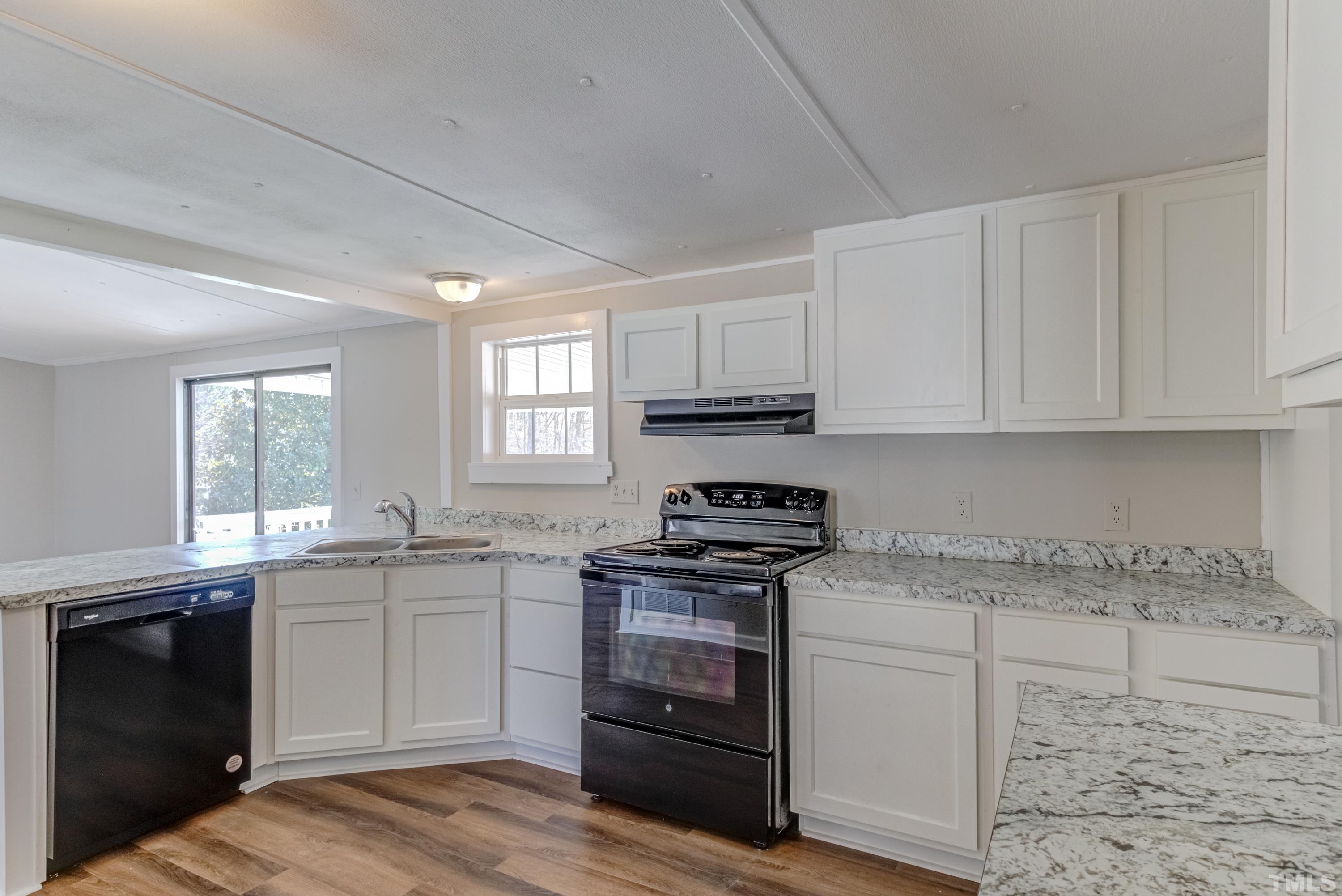 807 Lipscomb Road Angier, NC 27501 - Photo 24 of 39 a kitchen with stainless steel appliances granite countertop a stove sink and cabinets