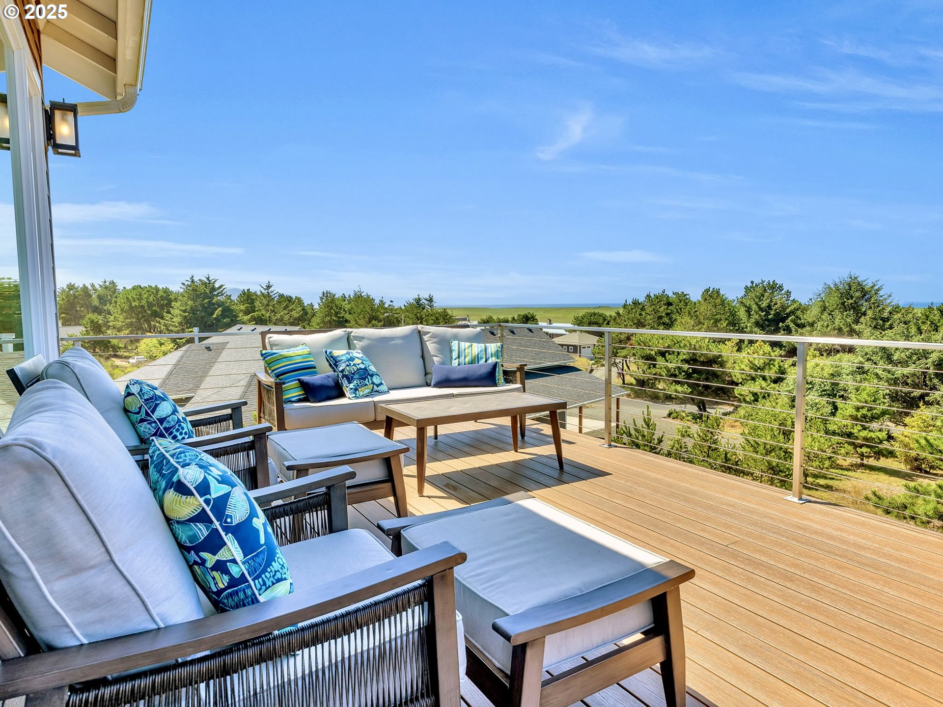 90043 Ocean Drive Warrenton, OR 97146 - Photo 14 of 48 a view of a balcony with wooden chairs and a floor to ceiling window