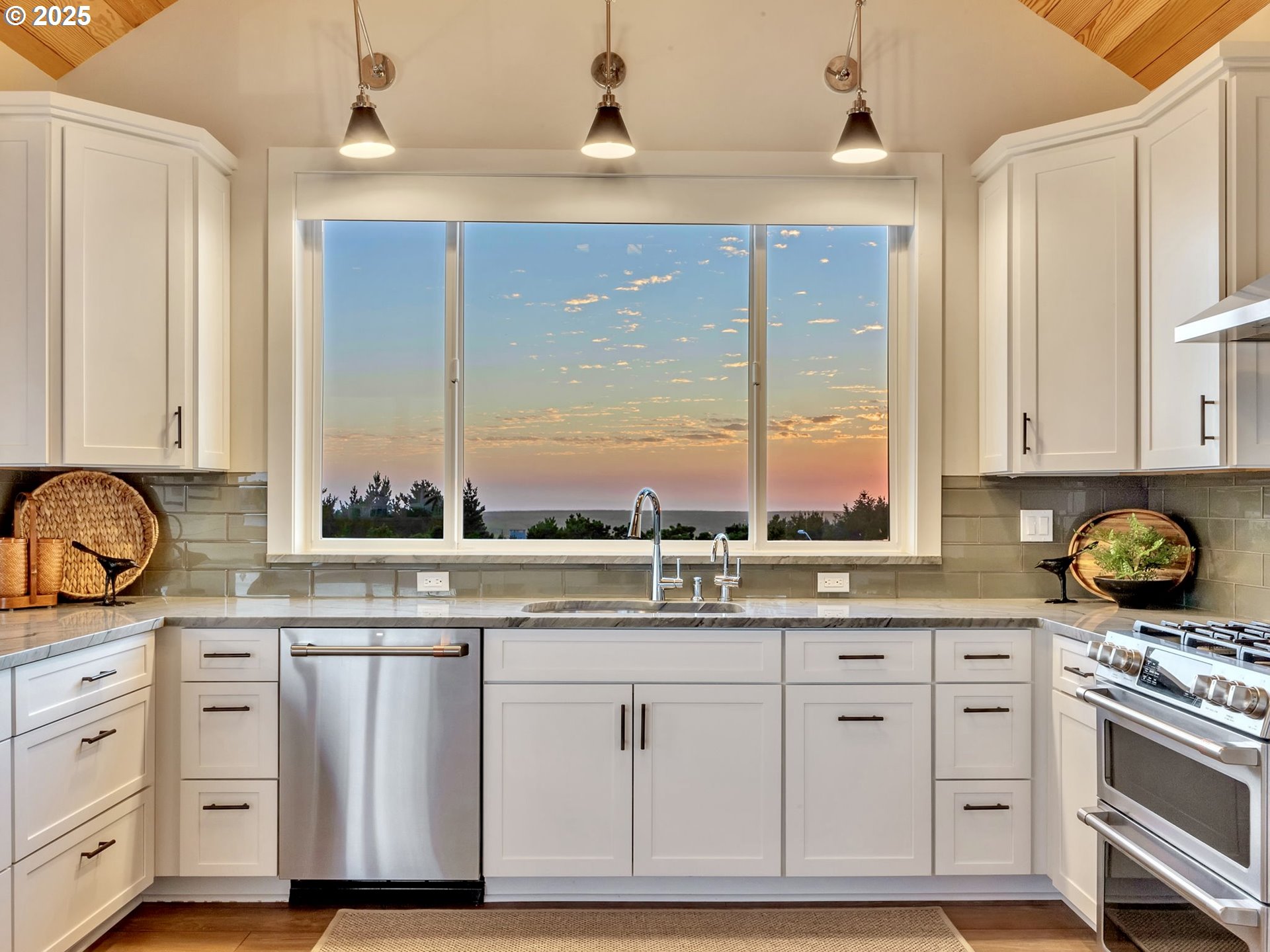 90043 Ocean Drive Warrenton, OR 97146 - Photo 23 of 48 a kitchen with granite countertop a stove a sink and white cabinets with wooden floor