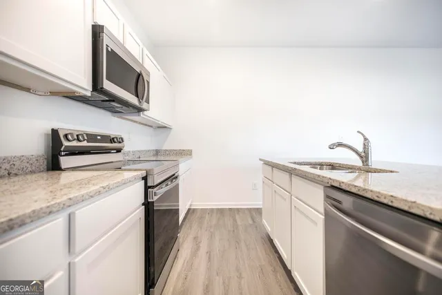 a kitchen with stainless steel appliances granite countertop a sink stove and microwave