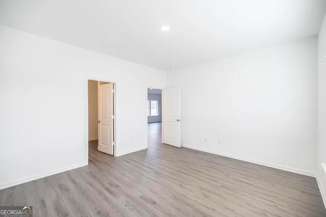 an empty room with wooden floor and window