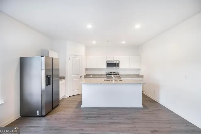 a kitchen with stainless steel appliances granite countertop a refrigerator and a sink