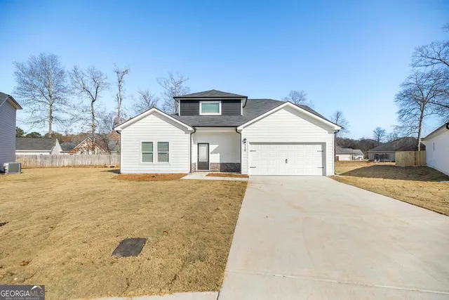 a view of a house with a yard and garage