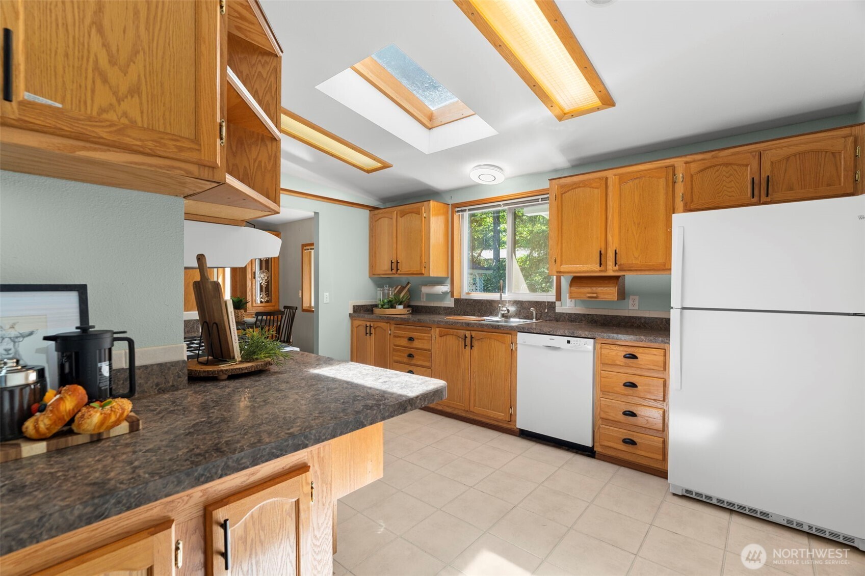 3758 Aiken Road Southeast Port Orchard, WA 98366 - Photo 14 of 40 a kitchen with granite countertop a refrigerator a sink a stove and cabinets