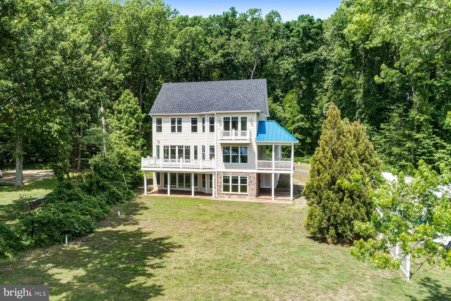 Waterside of home with multiple decks and porches