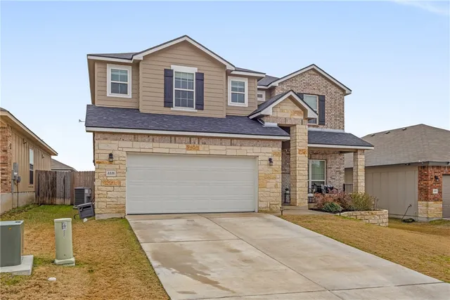 a front view of a house with a yard and garage
