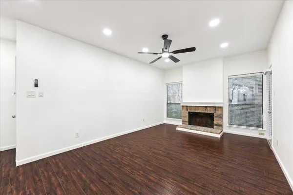 a view of empty room with wooden floor and fireplace