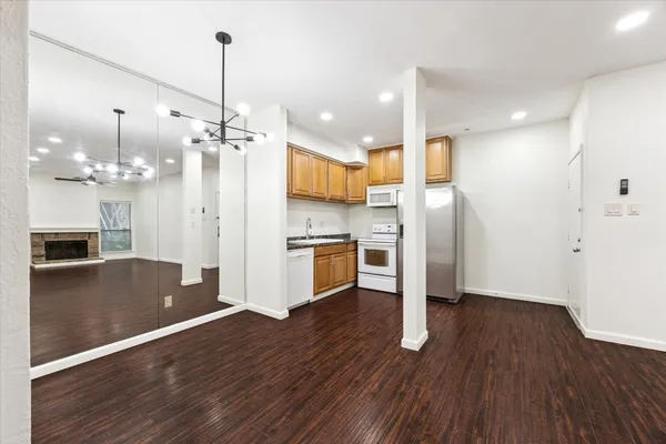 a view of kitchen with refrigerator microwave and wooden floor