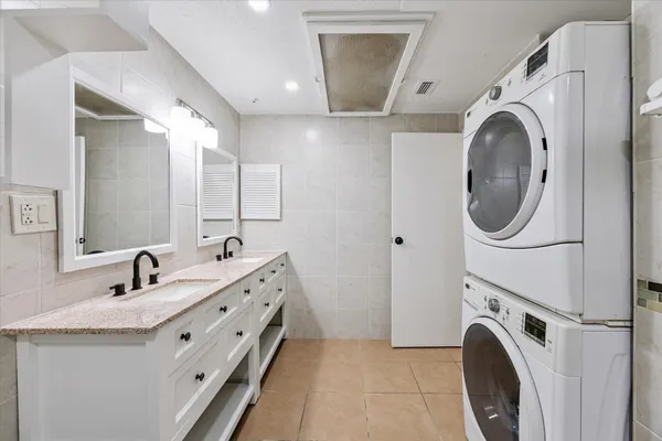 a bathroom with a sink mirror and washer