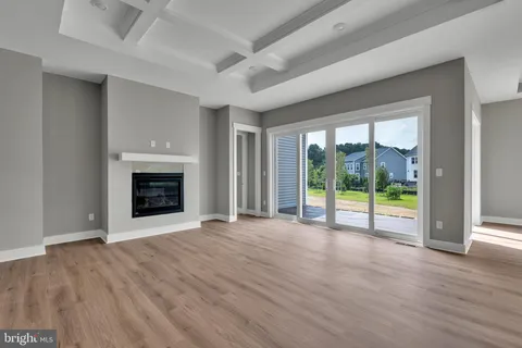 a view of empty room with wooden floor and fireplace