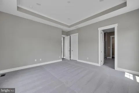 a view of an empty room with closet and a window