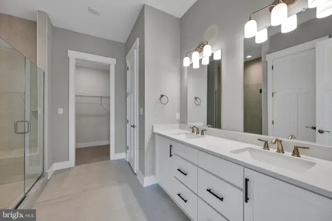 a bathroom with double vanity sinks and a shower