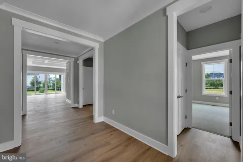 a view of a hallway with wooden floor and windows