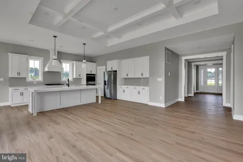 a large kitchen with a lot of counter space and wooden floor