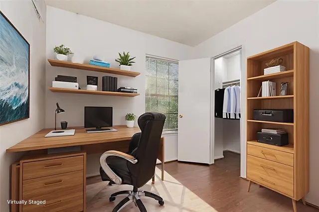 a view of a workspace with furniture and a window