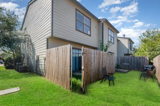 a view of backyard with potted plants and wooden fence