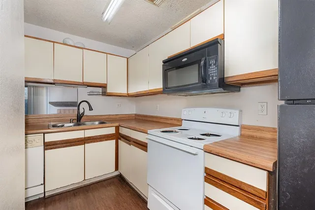 a kitchen with cabinets appliances a sink and a counter top space
