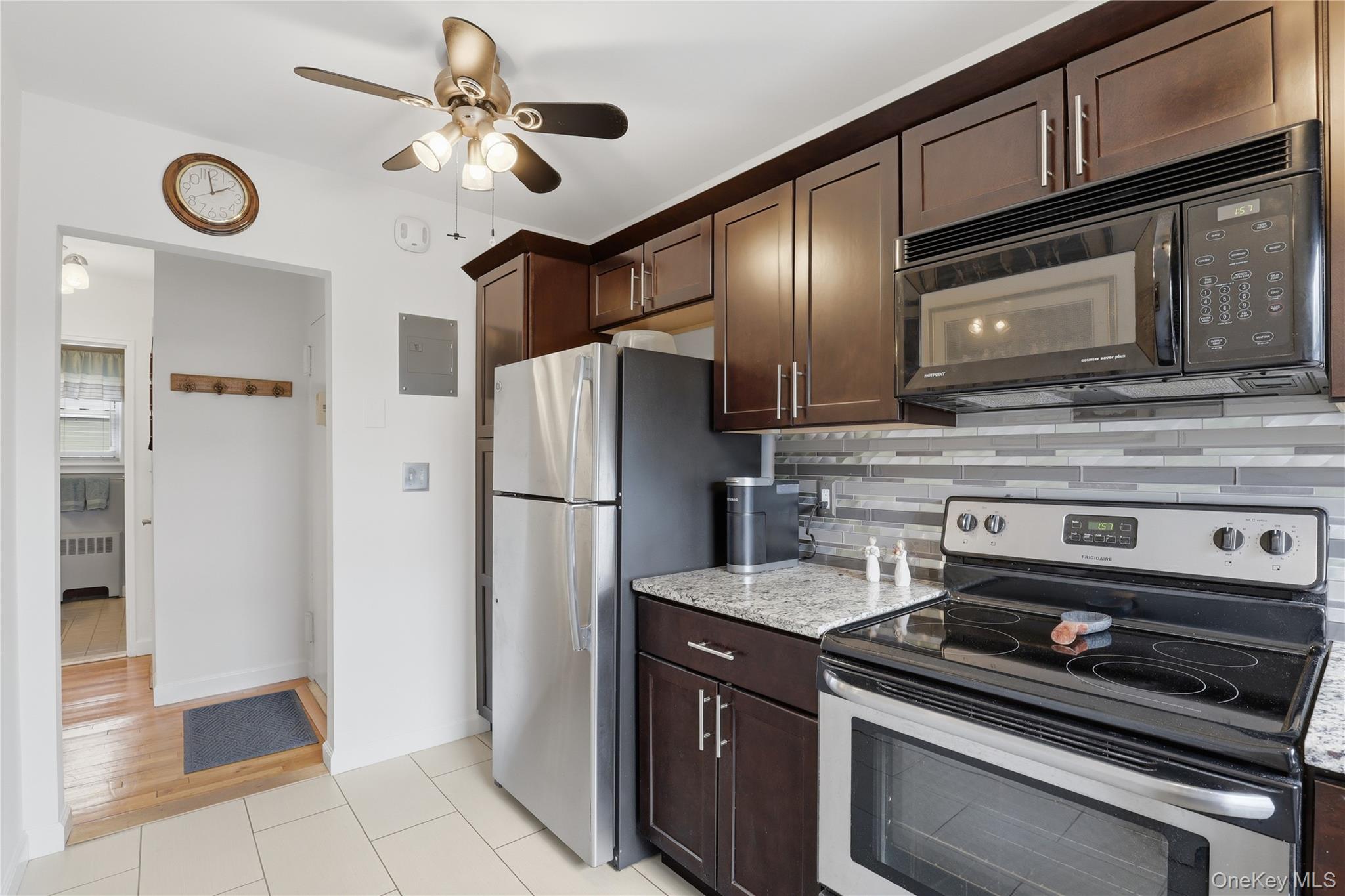 352 North State Road, Unit 1H Briarcliff Manor, NY 10510 - Photo 11 of 20 a kitchen with stainless steel appliances granite countertop a refrigerator a stove and a sink with cabinets