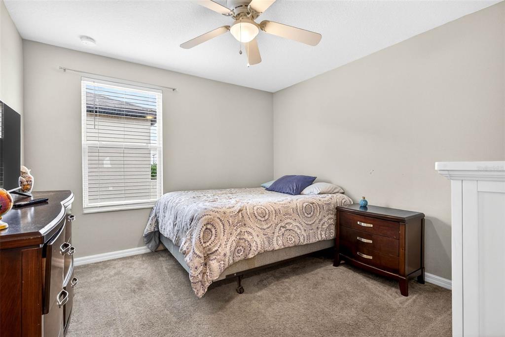 9616 Lemon Drop Loop Sun City Center, FL 33573 - Photo 37 of 53 a bedroom with a bed and a chandelier