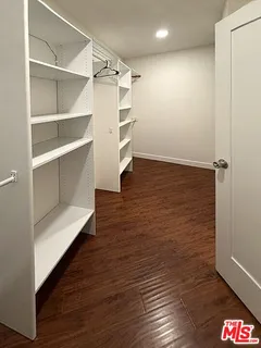 a view of walk in closet with empty racks
