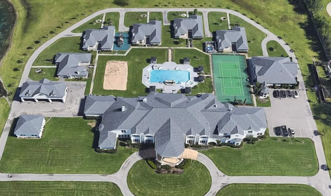 19525 Doerre Road Spring, TX 77379 - Photo 2 of 39 This aerial photo showcases a luxurious residential area with spacious, detached homes, featuring well-maintained lawns and amenities such as a swimming pool and a tennis court, indicating a high-end, community-oriented neighborhood.