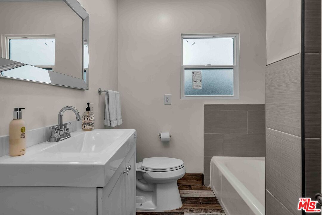 11575 Riverside Drive Valley Village, CA 91602 - Photo 11 of 16 a bathroom with a toilet a sink and mirror